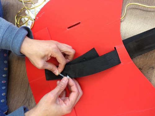 步驟 4: 然後把彩麗皮或書包帶用索帶固定在PP板上，整成頭套。